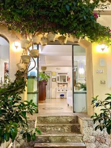 een open deur naar een woonkamer met planten bij Hotel Sylesia in Letojanni
