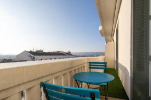 a patio with two chairs and a table on a balcony at LA SUITE MARCELLIN - Magnifique T3 avec garage et balcon Lyon 7 in Lyon