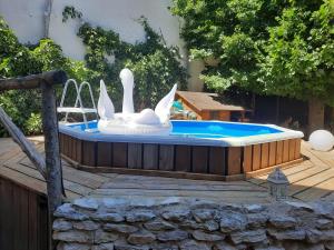 una piscina con 2 cisnes en una terraza de madera en Le clos du coteau, en Vendeuvre-du-Poitou