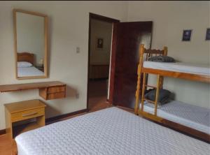 1 Schlafzimmer mit 2 Etagenbetten und einem Spiegel in der Unterkunft Apartamento Central, quarto andar in Serra Negra