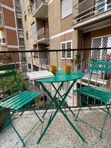 - Balcón con mesa verde y 2 sillas en Casa Vacanze Marzia, en Roma