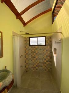 a bathroom with a shower and a tile wall at Glamping Campo Alegre in Cartago