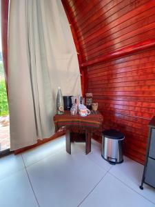 Una pequeña mesa en una habitación con una pared de madera en Glamping Campo Alegre en Cartago