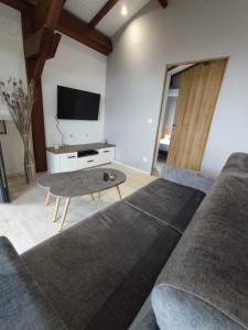 a living room with a couch and a table at Chalet Iris in Le Lambert