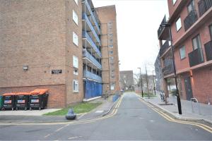 an empty street in front of a brick building at London zone2 Classic 3 bedroom in London
