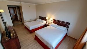 Habitación de hotel con 2 camas y TV de pantalla plana. en Hotel Diego de Almagro Punta Arenas en Punta Arenas