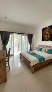 a bedroom with a large bed with a statue of a head at Gerke House in Ubud