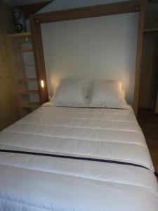 1 cama blanca grande con sábanas y almohadas blancas en Orelle 3 Vallées - 2 pièces 4 personnes, en Orelle
