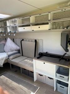 Zimmer mit einem Bett und einem Schreibtisch mit einem TV in der Unterkunft Wohnwagen Beachy direkt am Achterwasser in Lütow