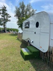 einem weißen Wohnwagen neben einem Zaun in der Unterkunft Wohnwagen Beachy direkt am Achterwasser in Lütow