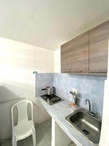una pequeña cocina con fregadero y una silla blanca en 2023 Apartamentos Múltiples Segundo Piso Casa Independiente, en Santa Marta