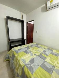1 dormitorio con 1 cama con edredón amarillo y gris en 2023 Apartamentos Múltiples Segundo Piso Casa Independiente, en Santa Marta