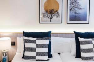 a white couch with pillows and framed pictures on the wall at Modern and luxury- 2Bd 2Bth- Socorro in Seville