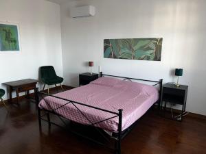 a bedroom with a bed with a purple comforter at Villa Gabry e Villa Fiorita in Camaiore