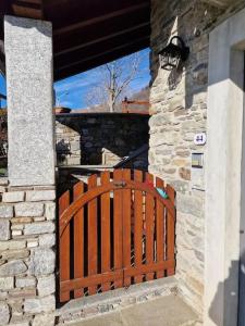 un cancello in legno di fronte a un muro di pietra di Casa Parido a Livo
