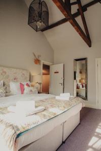 a bedroom with a large bed and a mirror at Plum and Partridge Husthwaite in York