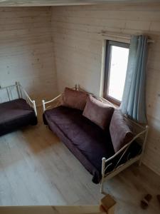 ein Wohnzimmer mit einem Sofa und einem Fenster in der Unterkunft Domek nad Wisłą 