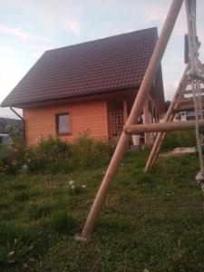 eine hölzerne Schaukel vor einem Haus in der Unterkunft Domek nad Wisłą 