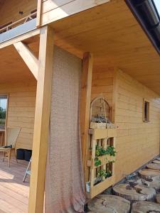 einen seitlichen Blick auf ein Haus mit einer Holzwand in der Unterkunft Domek nad Wisłą 