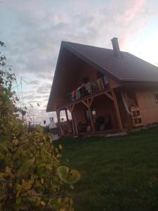 ein Haus mit einem schwarzen Dach auf dem Gras in der Unterkunft Domek nad Wisłą 