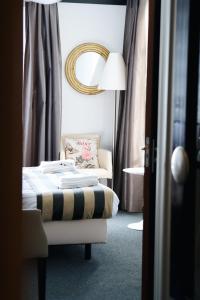 a bedroom with a bed and a chair and a mirror at Hotel de Wijnberg in Bolsward