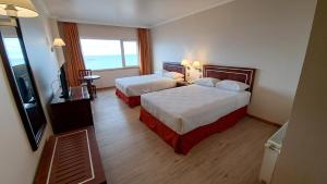 a hotel room with two beds and a television at Hotel Diego de Almagro Punta Arenas in Punta Arenas