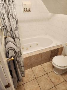 bagno con vasca e servizi igienici di Auberge Vue d'la Dune - Dune View Inn a Bouctouche