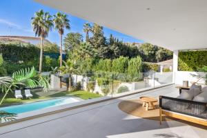 otwarty salon z widokiem na basen i palmy w obiekcie Brand New Modern 5 BDRM Villa in Puerto Banús w Marbelli