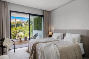 sypialnia z dużym łóżkiem i dużym oknem w obiekcie Brand New Modern 5 BDRM Villa in Puerto Banús w Marbelli +37 zdjęć