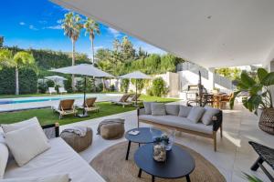 salon z białymi meblami i basenem w obiekcie Brand New Modern 5 BDRM Villa in Puerto Banús w Marbelli