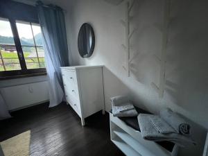 Habitación blanca con tocador y espejo en Casa Ucliva - Charming Alpine Apartment Getaway in the Heart of the Swiss Alps, en Rueras