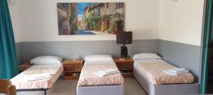 three beds in a room with a painting on the wall at Juliet - apartment in Liguria 5 Terre UNESCO site in Levanto