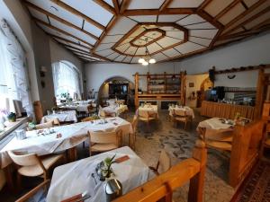 a restaurant with white tables and chairs and a large ceiling at Hotel Koruna in Jeseník