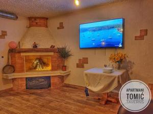 a living room with a fireplace and a tv on the wall at Apartment Tomić 3 Makarska in Makarska