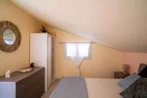 um quarto com uma cama, um espelho e uma janela em Casa Vacanza Giugiò em Giardini Naxos
