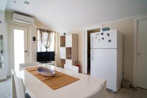 eine Küche mit einem Tisch und einem weißen Kühlschrank in der Unterkunft Casa Vacanza Giugiò in Giardini-Naxos