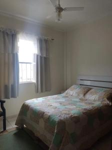 a bedroom with a bed in front of a window at Apartamento Central, oitavo andar in Serra Negra +18 photos