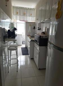 a kitchen with white appliances and a table and chairs at Apartamento Central, oitavo andar in Serra Negra