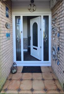 una puerta delantera de una casa con una puerta blanca en Lowefield B&B, en Plean