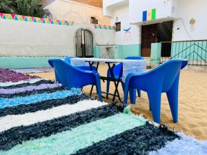 une table et des chaises au milieu d'une pièce avec du sable dans l'établissement Napata Guest House, à Assouan