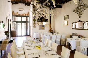 a dining room with white tables and white chairs at Agriturismo Casalicchio in Cammarata