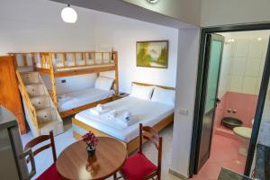 a small room with a bed and a table and chairs at Guest House Gerard in Ksamil