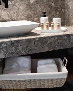 een badkamer met een wastafel en een mand met handdoeken bij Kaktus Suites Private Pool in Paliouri