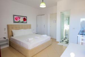 Schlafzimmer mit einem Bett und einer Glastür in der Unterkunft Guest House Gerard in Ksamil