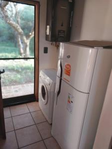 uma cozinha com um frigorífico e uma máquina de lavar roupa em Atardecida em Villa de Las Rosas