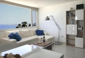 een woonkamer met een witte bank en een groot raam bij Fabulous upper floor sea view in San Agustin