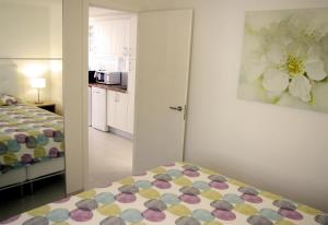 een kleine slaapkamer met een bed en een keuken bij Fabulous upper floor sea view in San Agustin +36 foto's