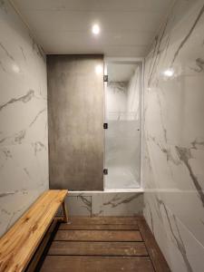 uma cabina de duche com um banco de madeira na casa de banho em Howard Johnson Hotel & Resort Funes em Funes