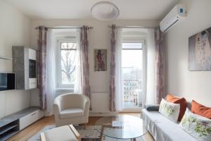 - un salon avec un canapé blanc et 2 fenêtres dans l'établissement An der Donau, 10 Minuten ins Zentrum, Klimaanlage, à Vienne