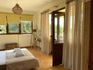 um quarto com uma cama e um quarto com uma janela em Minoa apartment in the heart of a Cretan village em Atsipopoulo